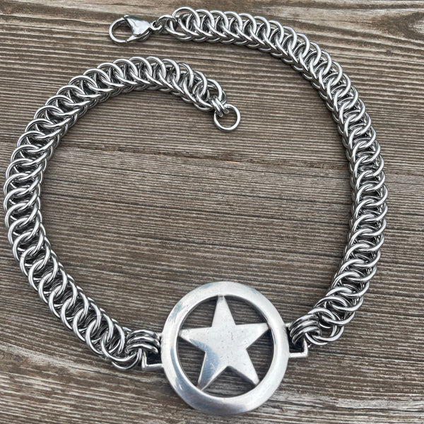 Silver chain necklace with star charm on a wooden surface